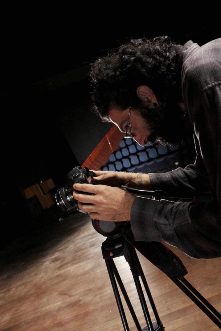 A picture of Farid taking pictures in a camera mounted in a tripod.