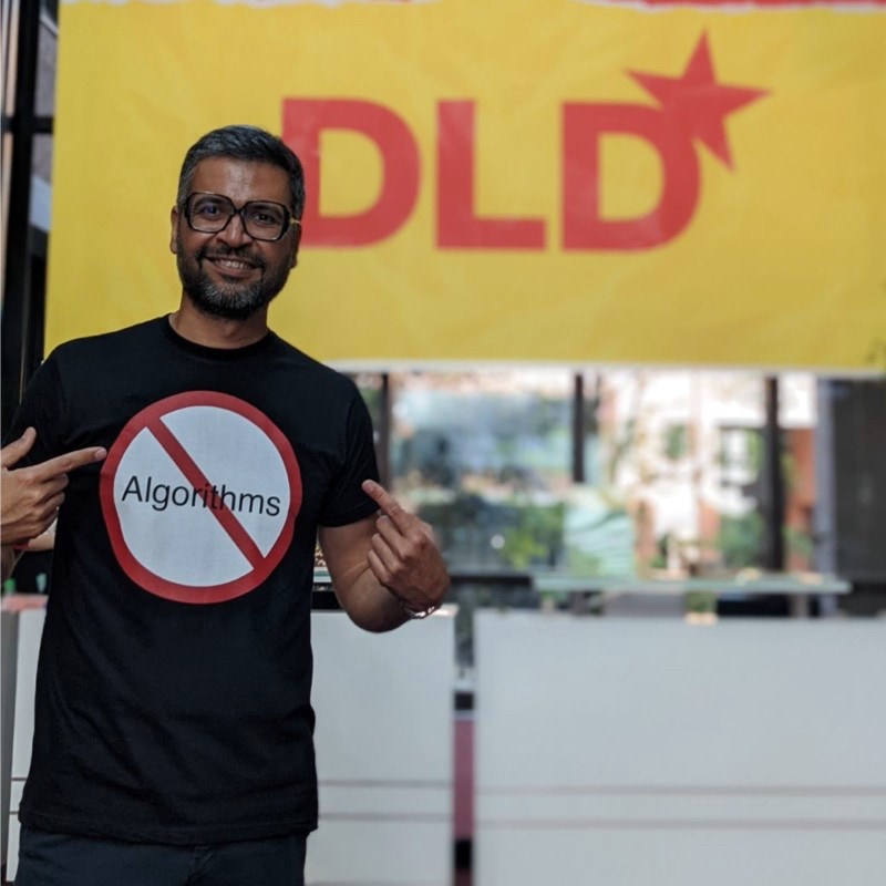 A picture of Neeraj Arora wearing a T-shirt with a forbidden sign over the word “algorithm”.