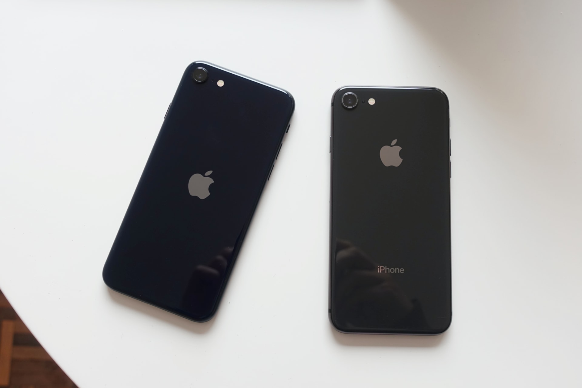 The new iPhone SE and an old iPhone 8, both black, but different blacks.